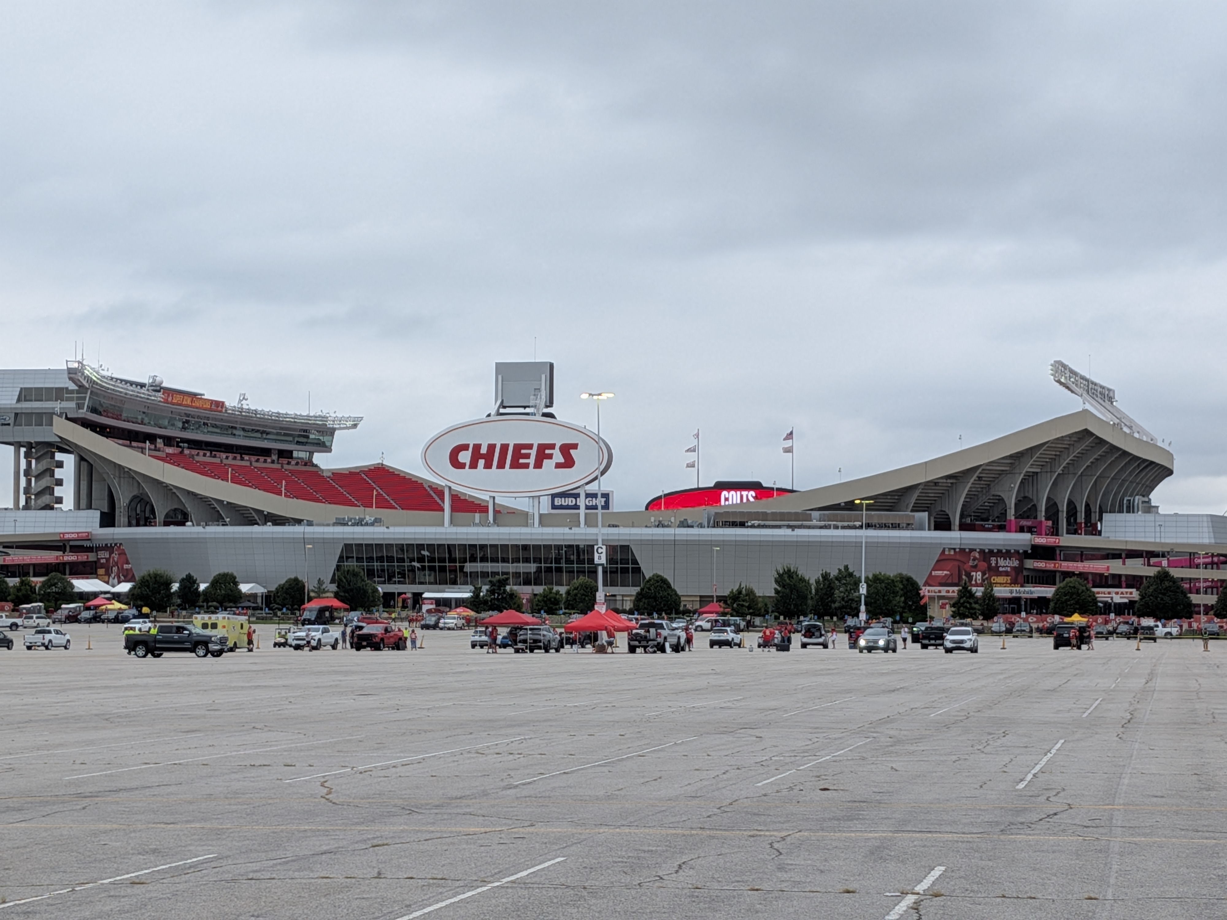 Arrowhead Stadium seen from the parking lot, with tailgaters and red tents set up in front