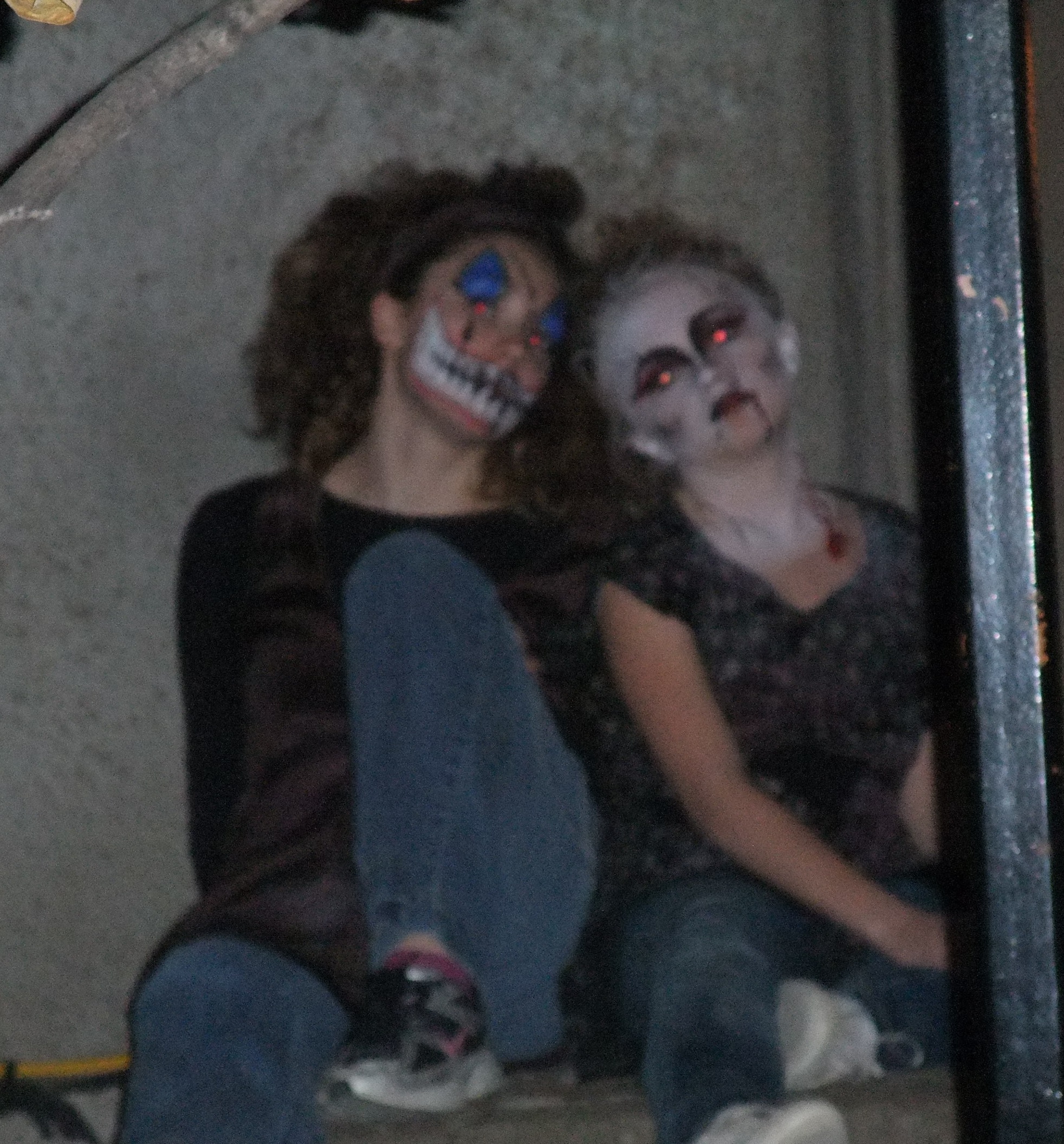 Two performers in clown and zombie makeup sitting on a step at The Edge of Hell
